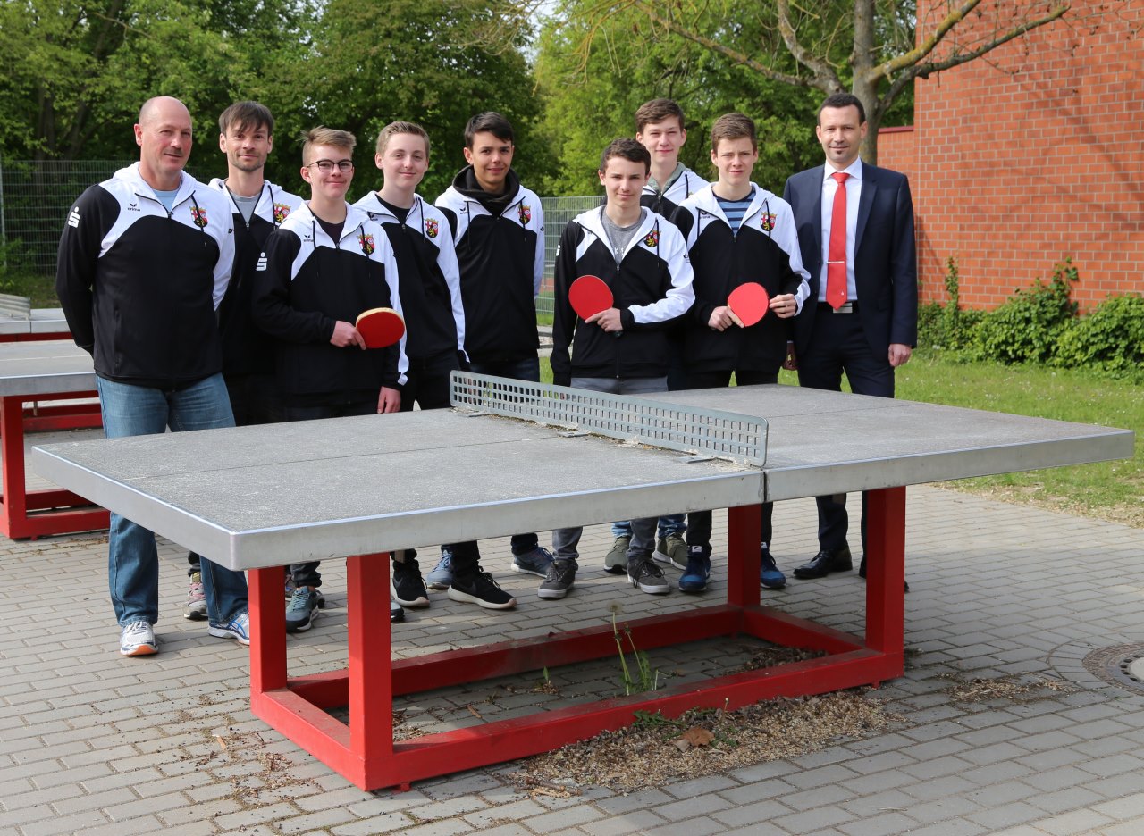 Tischtennisteam des Gymnasiums Nieder-Olm mit Filialdirektor Sven Mörsch von der Sparkasse Mainz hinter der Tischtennisplatte