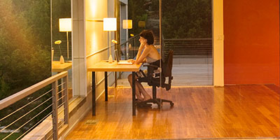 junge Frau sitzt in moderner, offener Immobilie am Laptop