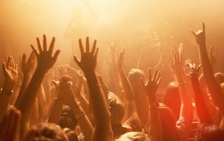 Leute feiern in einem Club mit Händen in der Luft