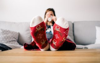 Frau mit Weihnachtssocken auf dem Sofa