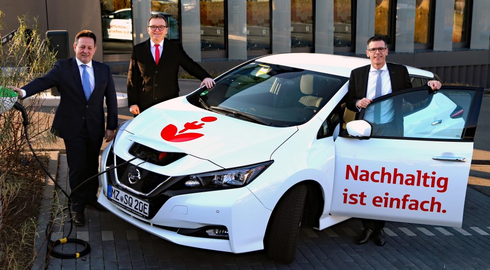 Michael Weil und Thorsten Mühl mit Wolf-Rüdiger Stahl vor dem neuen Elektroauto der Sparkasse Mainz