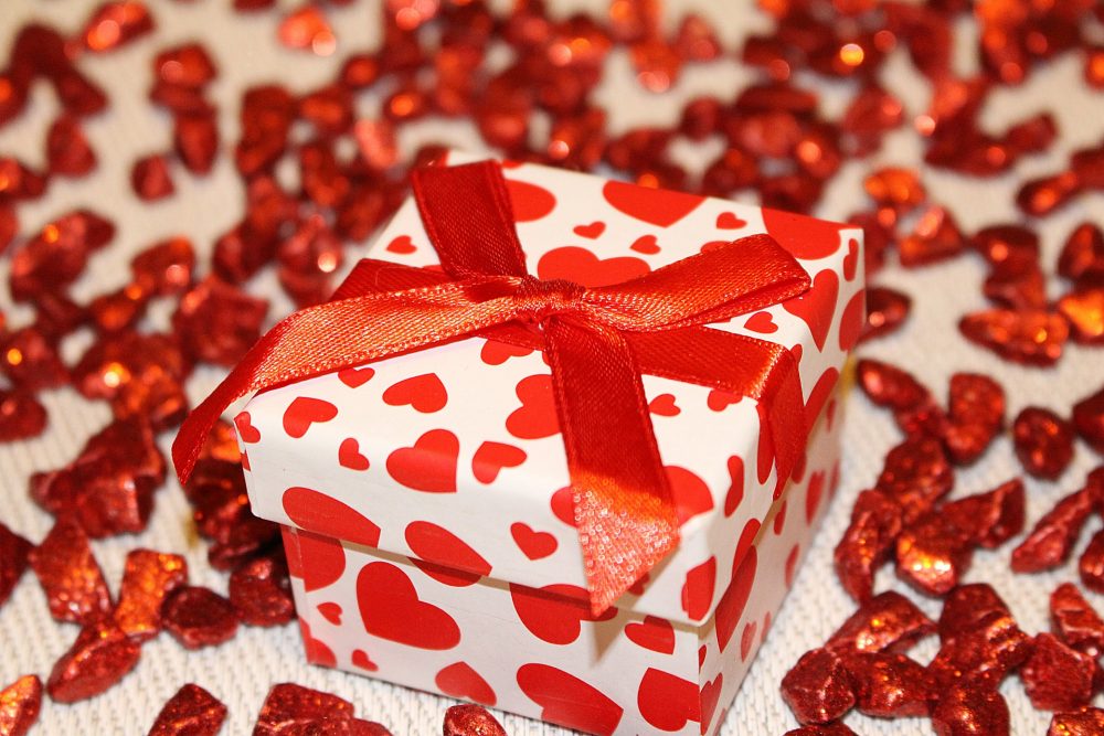 Geschenkbox mit roten Herzen und roter Dekoration