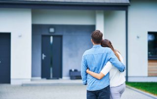 Junges Paar vor Einfamilienhaus