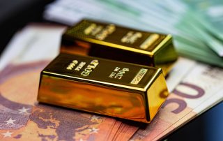 Zwei Goldbarren liegen auf Banknoten