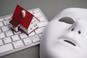 House, keyboard computer, white mask scammer on gray background.