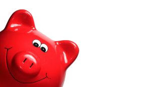 Sparschwein rot Ein rotes Sparschwein grinst vom linken unteren Bildrand den Betrachter an.